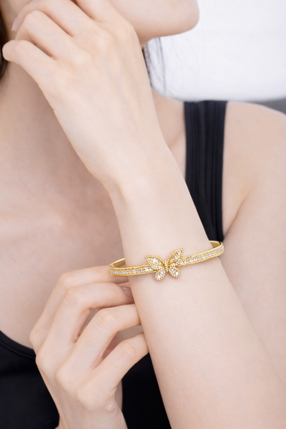 Golden open bracelet decorated in a butterfly shape