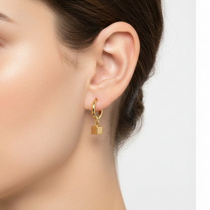 Gold earrings with square pendants.